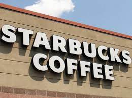 Starbucks sign displayed prominently on the exterior of a building. The familiar green and white logo is easily recognizable, signaling the presence of a Starbucks coffee shop within the establishment.