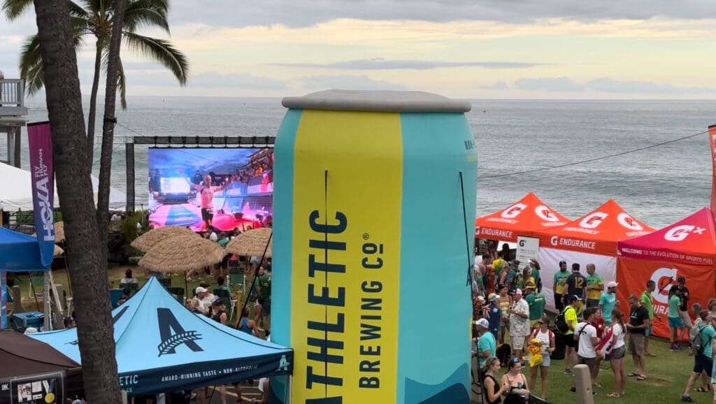 An expo scene at the World Championships Kona event featuring a prominent display of sponsor Athletic Brewing.