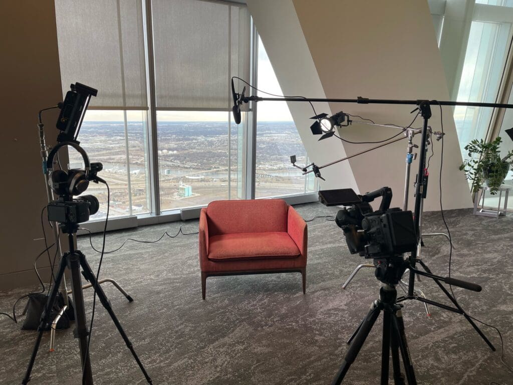 An improvised studio setup featuring a microphone, lights, smartphone, and camera. 