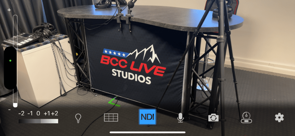 An expansive broadcast studio featuring professional-grade equipment and monitors. On the screens, NDI (Network Device Interface) tools are prominently displayed, facilitating seamless integration and transmission of audio and video signals over a network.