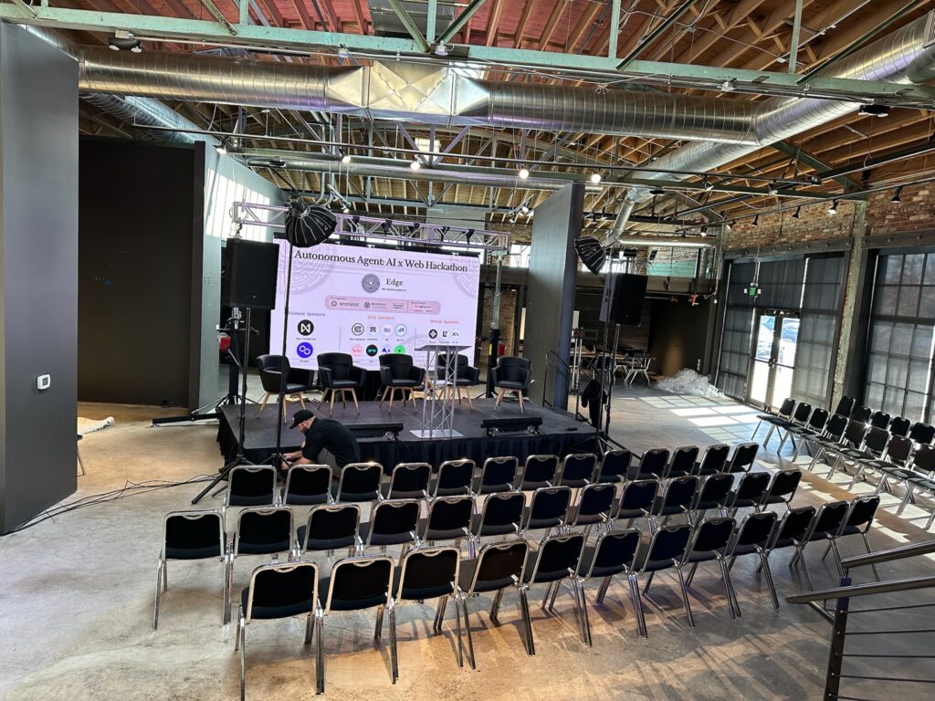 Stage set up for a panel of speakers with an LED screen behind it.