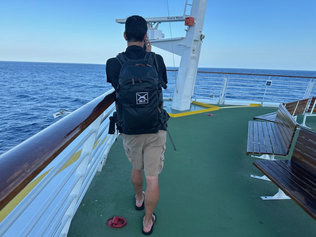 Videographer from behind while he shoots video on a cruise ship