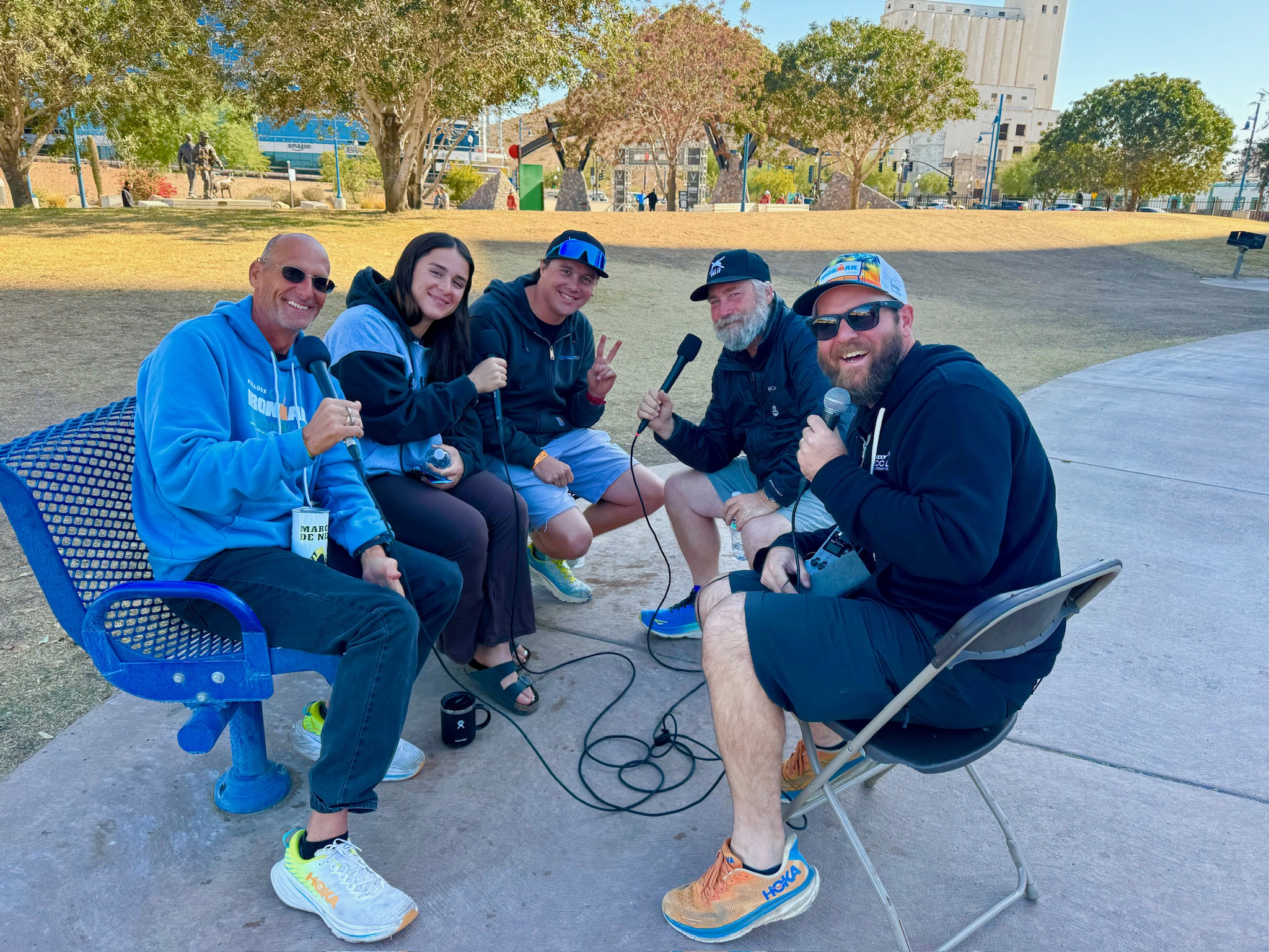 Group recording a podcast outside on chairs and benches